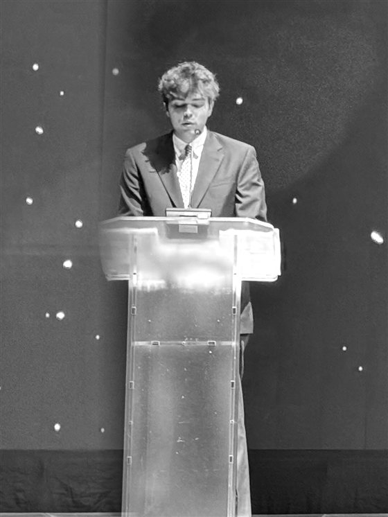 Bennett Kearney speaking on stage at a conference